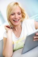 fille blonde heureuse à l'aide de tablette numérique