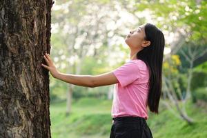 les femmes asiatiques embrassent les arbres avec amour, concept d'amour pour le monde photo