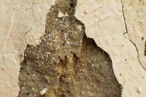 vieille texture de mur avec du plâtre cassé minable. ciment peeling plâtre fond texturé peeling fond blanc photo