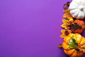 un cadre de citrouilles, feuilles d'érable jaunes, baies sur fond violet. récolte d'automne, humeur. copie espace, flatlay