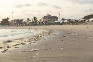 les sacs en plastique sur les plages de sable sont causés par l'action humaine. la crasse de la mer et le danger des déchets pour les animaux aquatiques photo