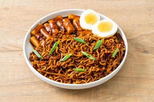 jjajang rabokki - nouilles instantanées coréennes ou ramyeon avec gâteau de riz coréen ou tteokbokki et œuf à la sauce aux haricots noirs photo