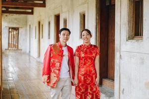 heureux jeune couple asiatique en robes traditionnelles chinoises photo