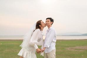 heureux jeune couple asiatique en vêtements de mariée et de marié