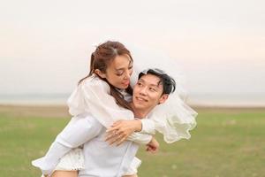 heureux jeune couple asiatique en vêtements de mariée et de marié