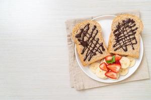 pain de blé entier avec banane fraîche, fraise et chocolat photo