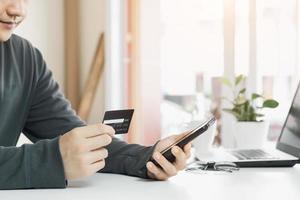 les hommes d'affaires utilisent leurs cartes de crédit via des applications bancaires mobiles sur Internet pour acheter des idées de paiement en ligne et numériques. photo