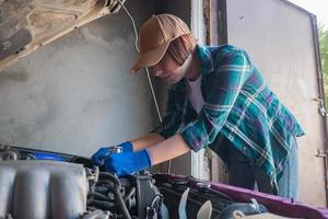 Mécanicien féminin réparant une voiture dans un garage photo