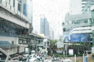 ville du matin, vue par la fenêtre le jour de pluie. gouttelettes d'eau sur le verre un jour de pluie. gouttes de pluie pendant la pluie en jour de pluie à l'extérieur du verre de la fenêtre avec un arrière-plan flou. photo