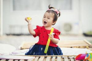 petite fille asiatique jouant avec des jouets à la maison photo