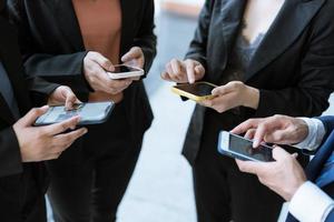 groupe de jeunes gens d'affaires debout et utilisant un smartphone ensemble des concepts de communication. photo