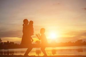 mère a encouragé son fils à l'extérieur au coucher du soleil, concept de silhouette photo