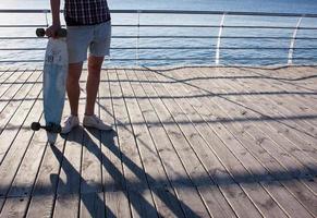 jeune patineur barbu sur la plage de la ville photo