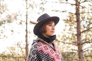 voyageur de femme hipster yong en chapeau et poncho marchant à l'extérieur photo