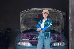 Mécanicien féminin réparant une voiture dans un garage photo