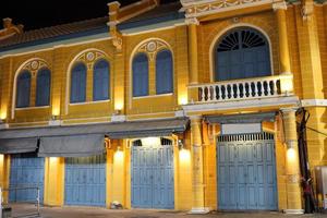 bâtiment rétro jaune, porte et fenêtre bleu-gris à bangkok la nuit, bâtiment de style européen. photo