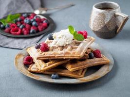 gaufres belges aux framboises, sirop de chocolat. petit déjeuner avec thé sur fond sombre, vue latérale photo