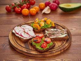 smorrebrod - sandwichs danois traditionnels. pain de seigle noir au poisson, anchois photo