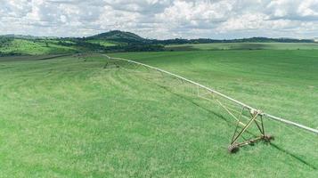 système d'irrigation agricole le jour d'été ensoleillé. une vue aérienne d'un système de gicleurs à pivot central. photo