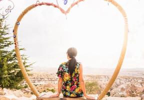 femme assise sur une balançoire et profitant du lever du soleil en turquie photo