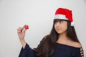 jeune femme en bonnet de noel tenant un cadeau de noël photo