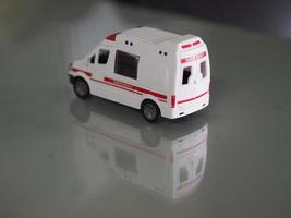 modèle d'urgence ambulance voiture de couleur blanche sur la réflexion de la table miroir