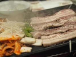 porc grillé à la thaï, buffet thaï avec porc, poulet et autres viandes, cuit sur une plaque de barbecue en laiton, grillade de porc, barbecue, barbecue thaï, barbecue coréen à la thaï, buffet barbecue thaï photo