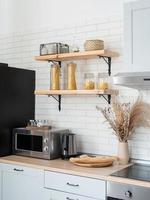 intérieur de cuisine de style rustique avec ustensiles de cuisine vintage et mur en bois. mobilier blanc et décor en bois dans un chalet lumineux à l'intérieur. photo