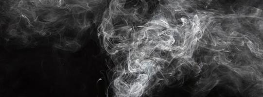 fumée isolée sur fond noir. mouvement de fumée blanche photo