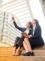 femme d'affaires caucasienne et asiatique heureuse et souriante après avoir réussi à trouver ses données commerciales photo