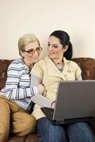 deux femmes discutent et travaillent sur un ordinateur portable photo