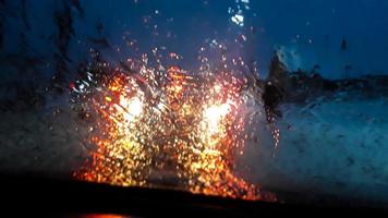 feux de voiture à travers une vitre humide photo