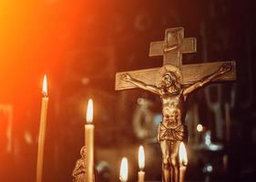 crucifixion dans l'église sur fond de bougies photo