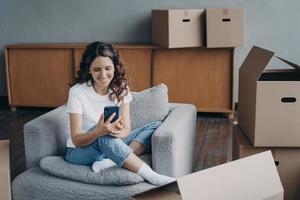 une femme satisfaite se déplace. la fille clique sur le téléphone et commande le service de livraison à l'aide de l'application. photo