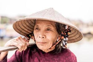 vieille femme sympathique avec chapeau de paille vietnamien photo