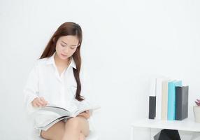 belle jeune femme asiatique sourire avec plaisir en lisant un livre, loisirs de fille avec magazine, concept d'éducation. photo