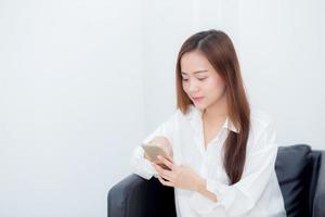 belle de portrait jeune femme asiatique souriante assise se détendre sur la chaise, fille à l'aide de téléphone portable intelligent parler profiter, concept de communication et de réseau social. photo