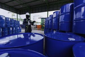 Travailleur de sexe masculin record d'inspection des barils de stock d'huile de tambour bleu vertical ou chimique
