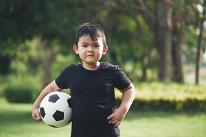 main de petit garçon tenant le football de football photo