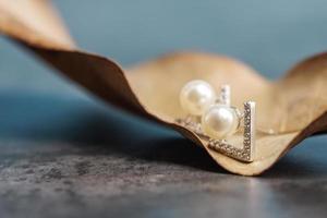 un beau clous d'oreilles en perles. gros plan de boucles d'oreilles en perles blanches. photo