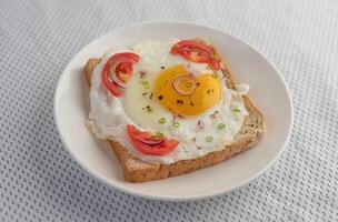pain posé avec un œuf au plat avec tomates, farine de tapioca. photo