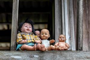 de nombreuses poupées sont assises sur les balcons de vieilles maisons en bois. photo