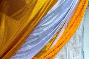 tissu à motifs jaune et blanc recouvrant le bouddha. photo