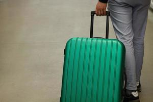 attendant à l'aéroport. le concept de vacances d'été, un voyageur avec une valise dans la zone d'attente du terminal de l'aéroport. mise au point sélective. photo