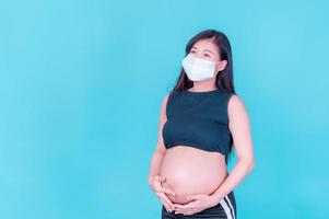 les femmes asiatiques enceintes doivent utiliser des masques pour se protéger contre la pollution par la poussière et pour prévenir l'infection par des virus photo