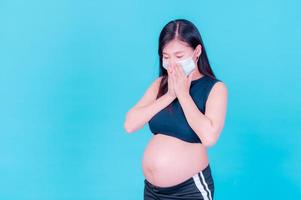 les femmes asiatiques enceintes doivent utiliser des masques pour se protéger contre la pollution par la poussière et pour prévenir l'infection par des virus photo