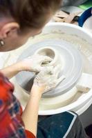 femme faisant de la poterie en céramique sur roue, gros plan des mains. concept pour femme en freelance