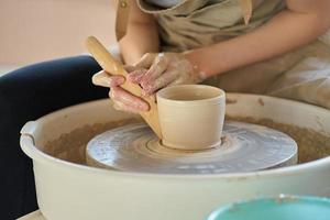 femme faisant de la poterie en céramique sur roue, mains en gros plan, se concentrant sur les potiers, palmiers avec poterie