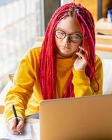 concept de nomade numérique. fille indépendante travaillant à distance sur un ordinateur portable dans un café, coworking.