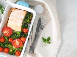 saumon de poisson cuit au four avec légumes, brocoli. régime alimentaire sain, toile de fond en marbre blanc, vue de dessus, gros plan